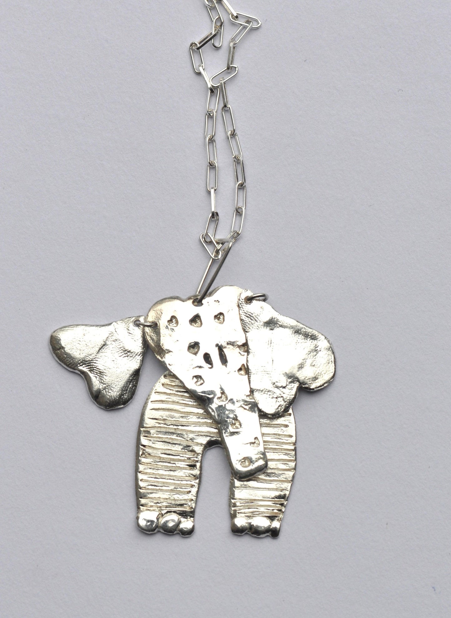 a silver elephant necklace on a chain