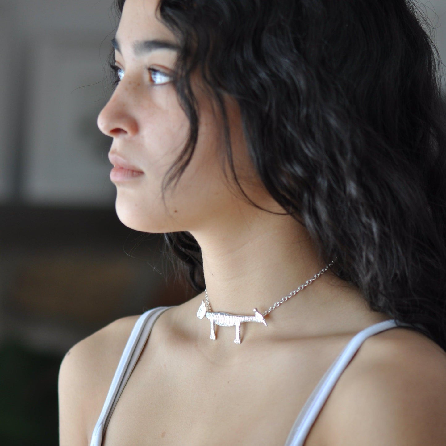 a woman wearing a necklace with a plane on it