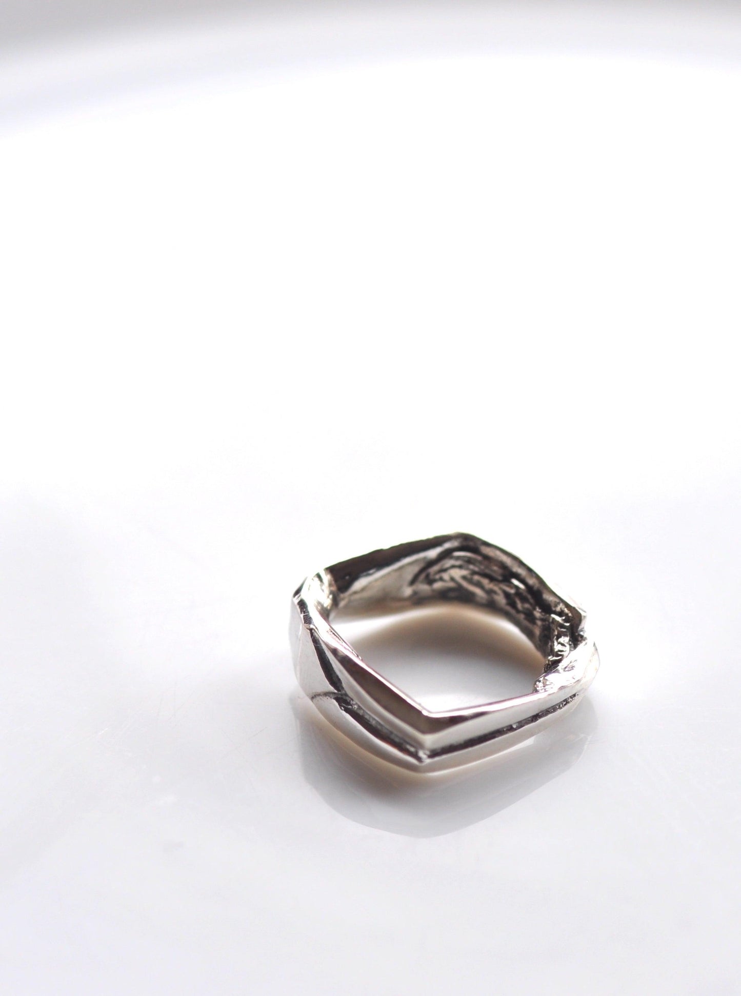 a silver ring sitting on top of a white table