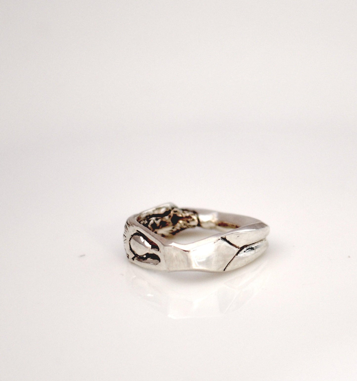 a silver ring sitting on top of a white table