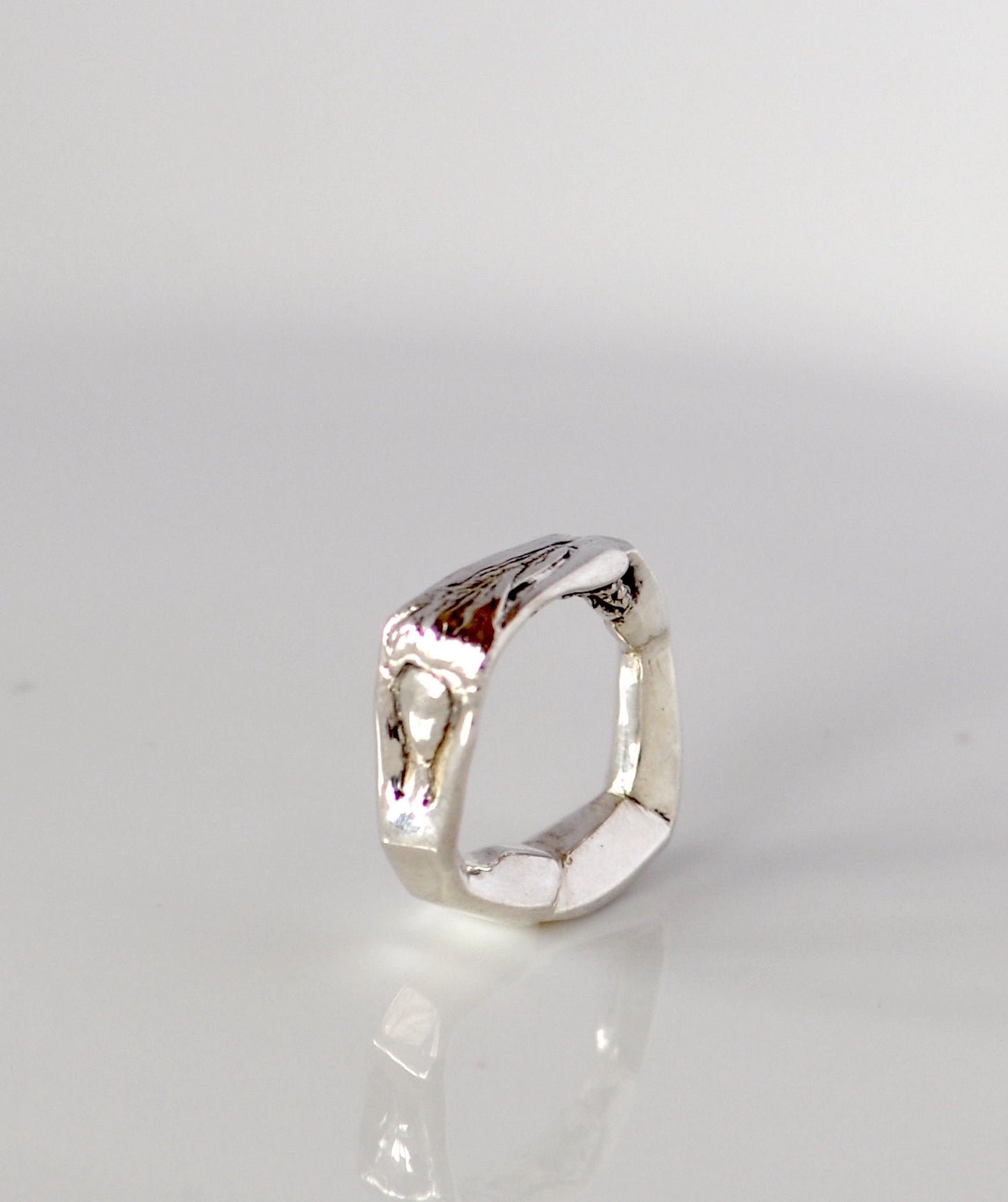 a close up of a silver ring on a white surface