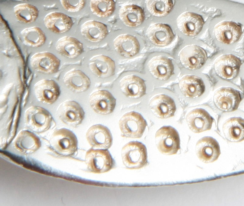 a close up of a metal object on a white surface