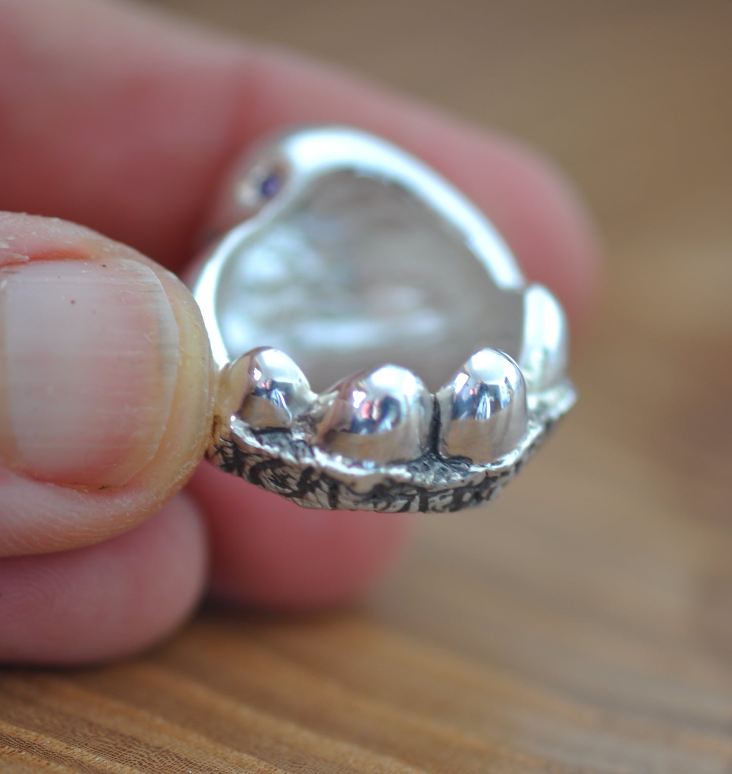 a close up of a person holding a silver ring