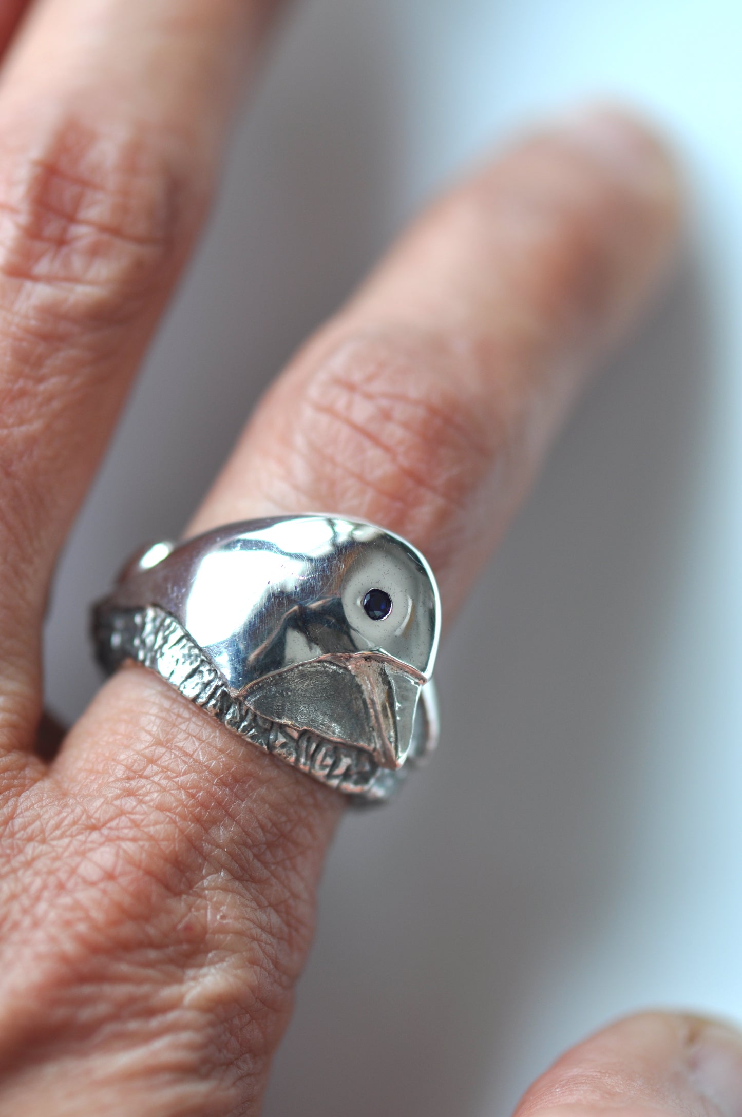 a close up of a person's hand with a ring on it