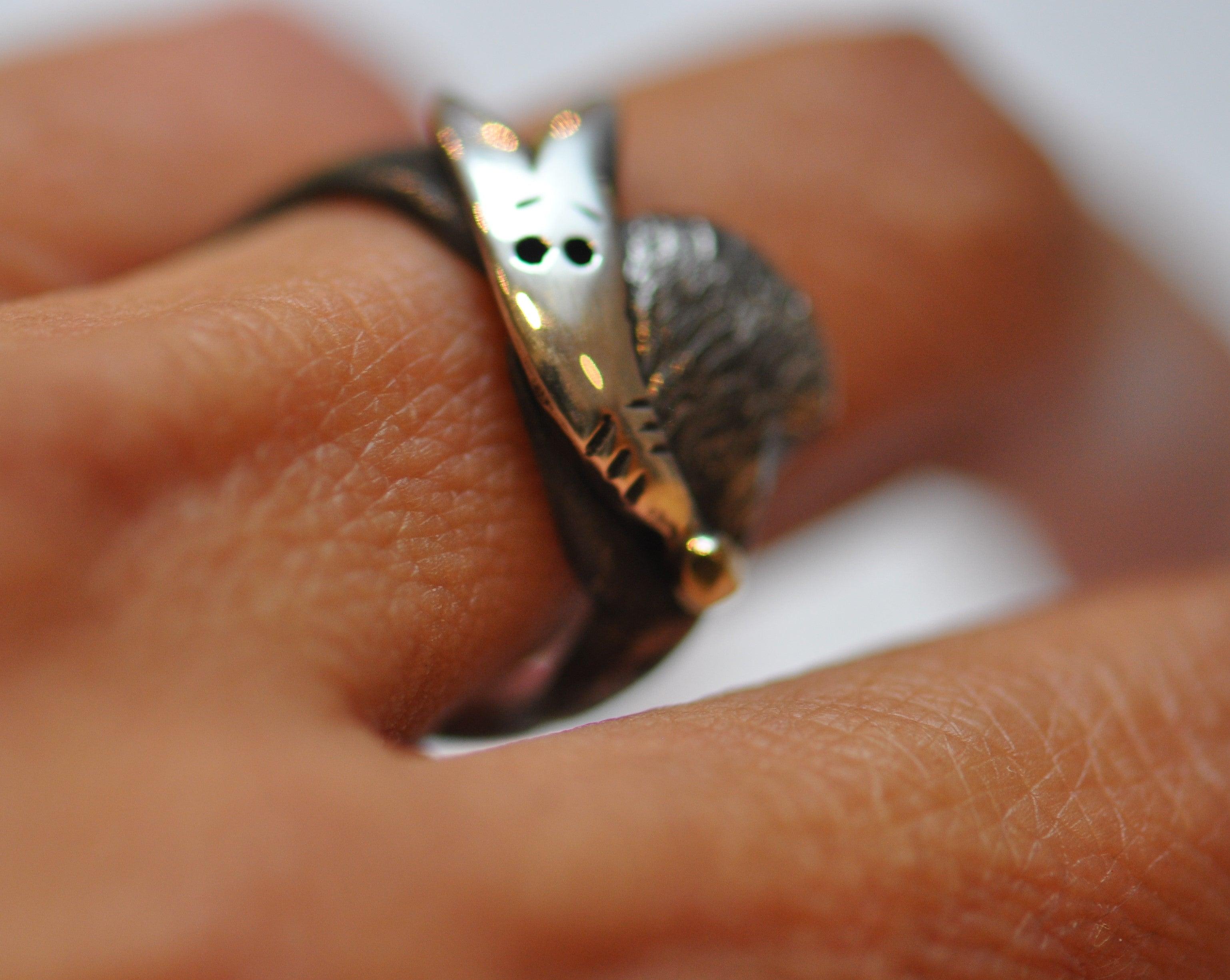 a close up of a person's hand with a ring on it