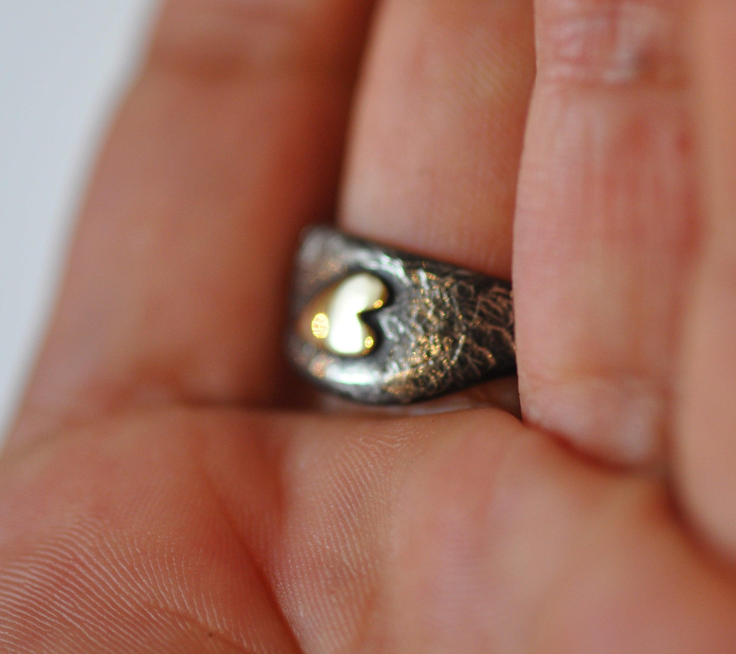 a close up of a person's hand holding a ring