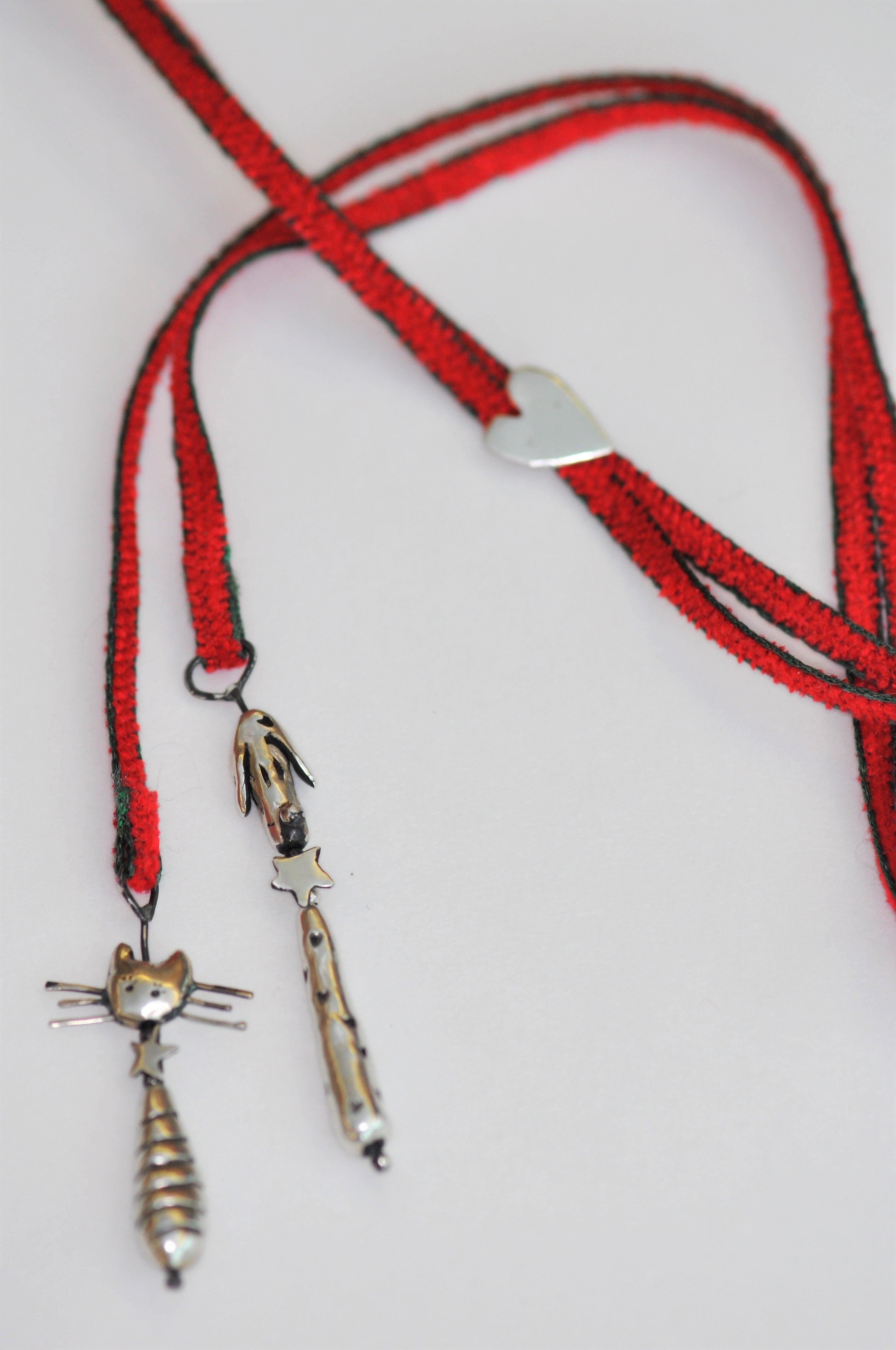 a red lanyard with a silver cat on it