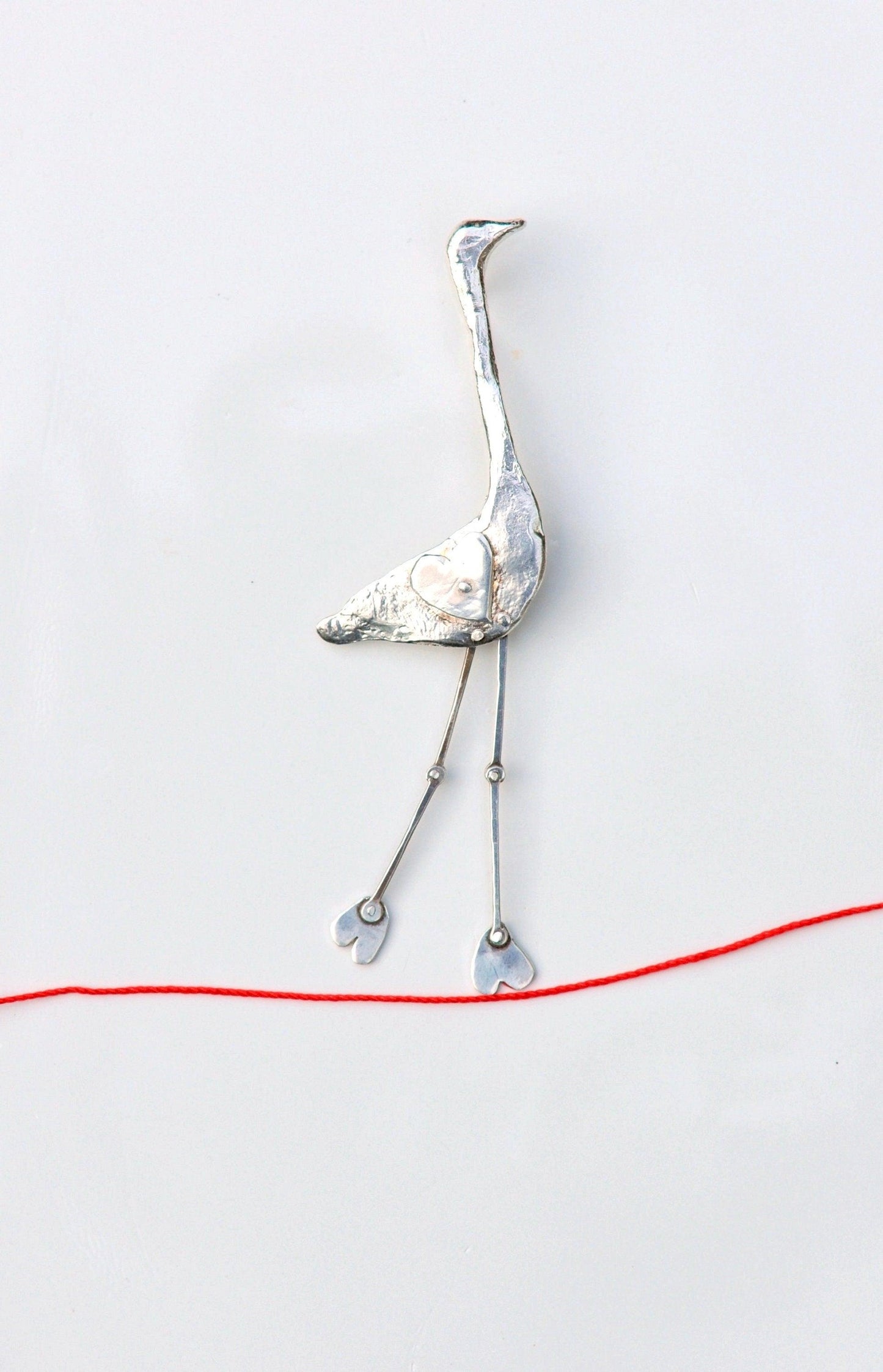 a bird made out of metal and wire on a white surface