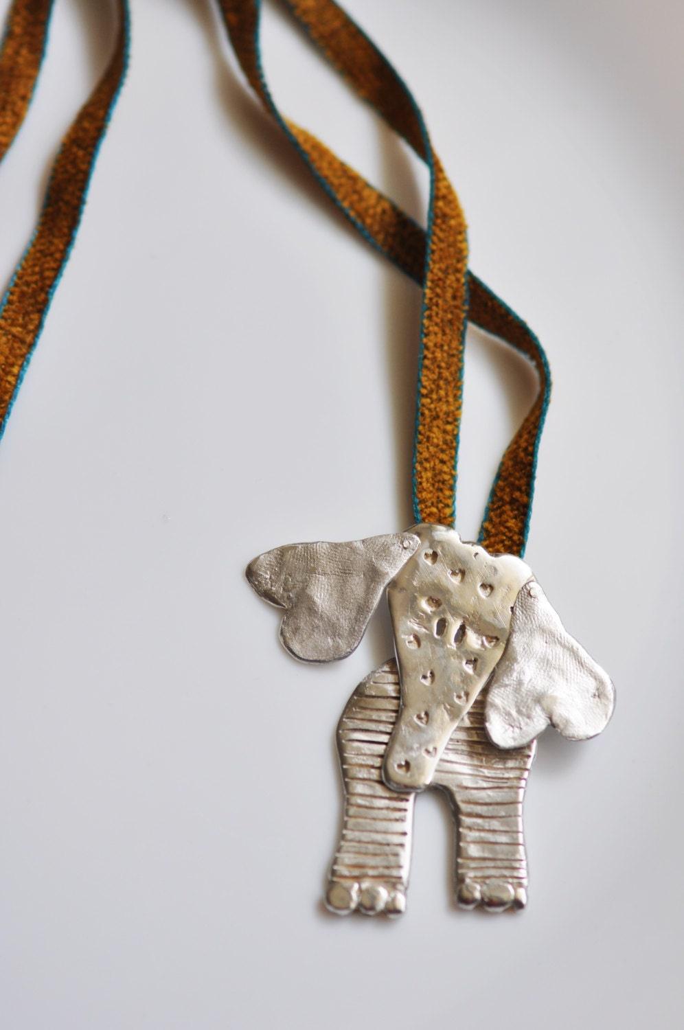 a silver elephant ornament hanging from a string