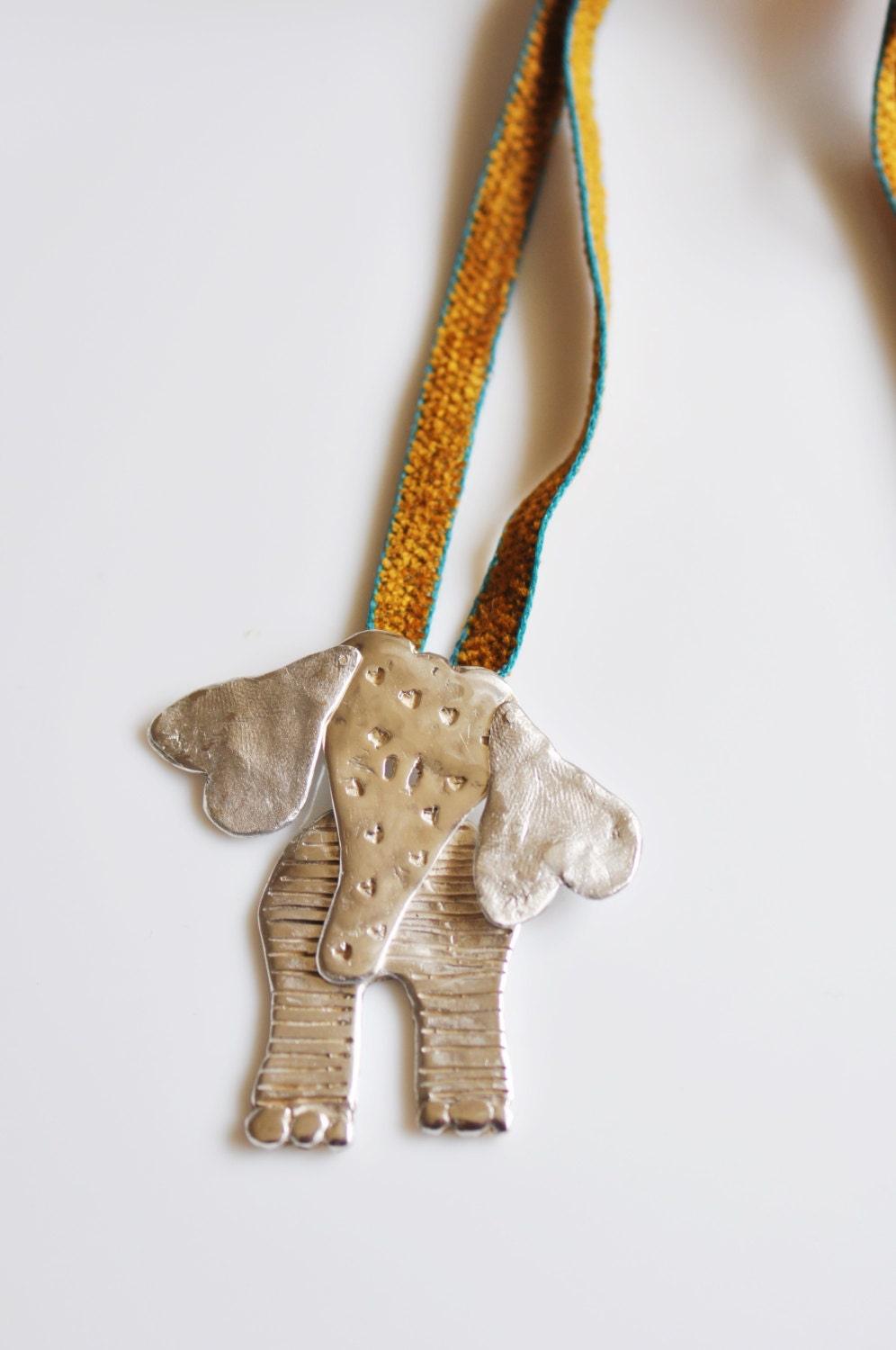 a silver elephant ornament hanging from a string