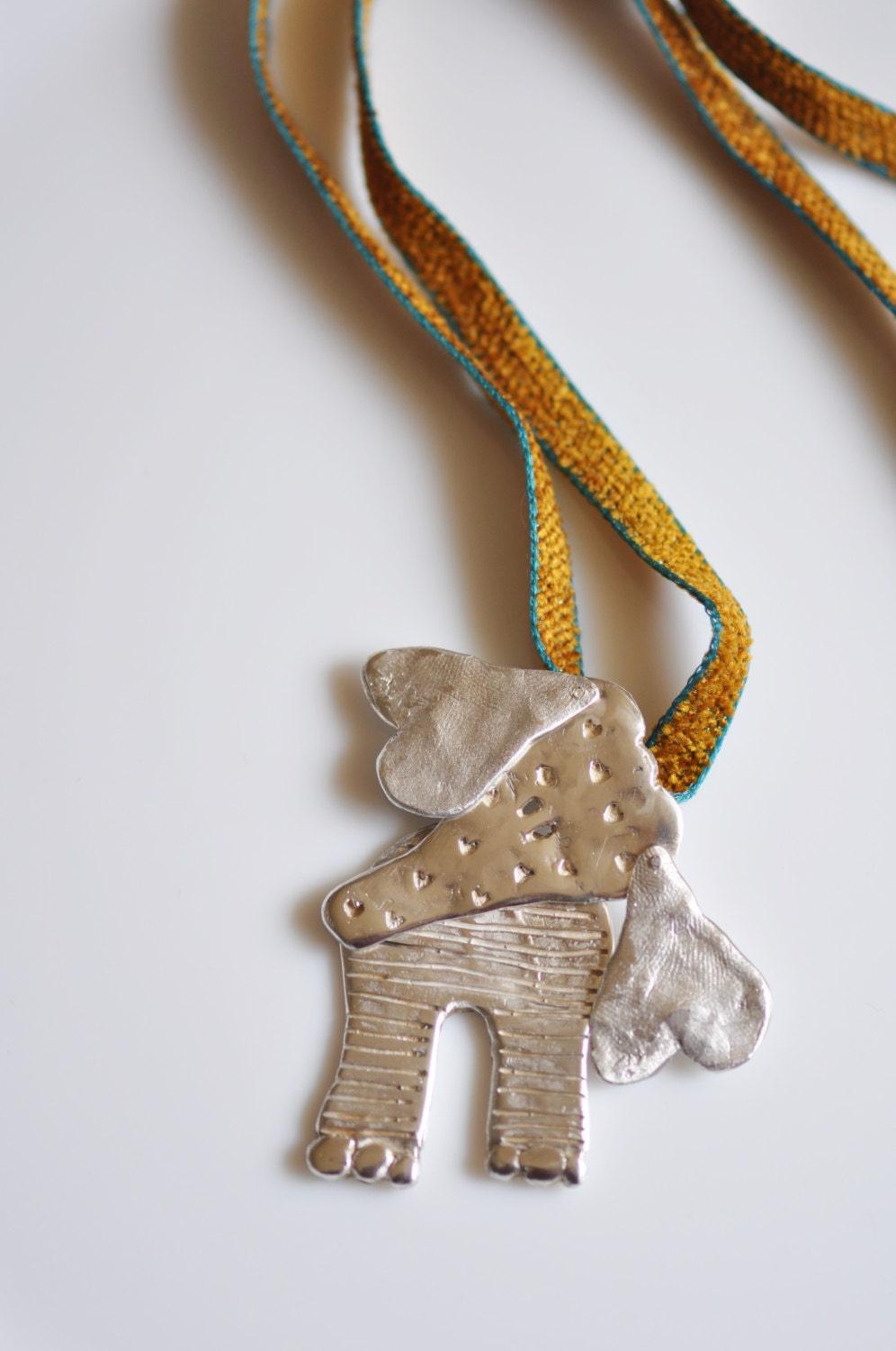 a silver dog ornament hanging from a string