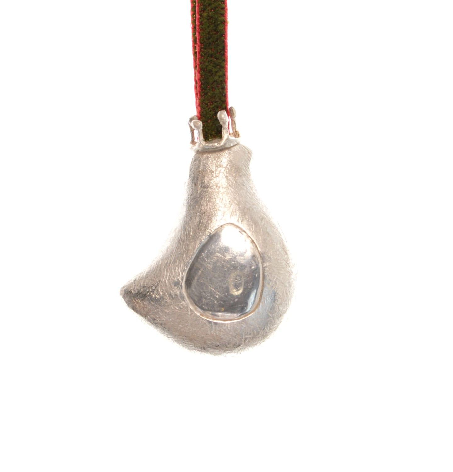 a silver object hanging from a red cord