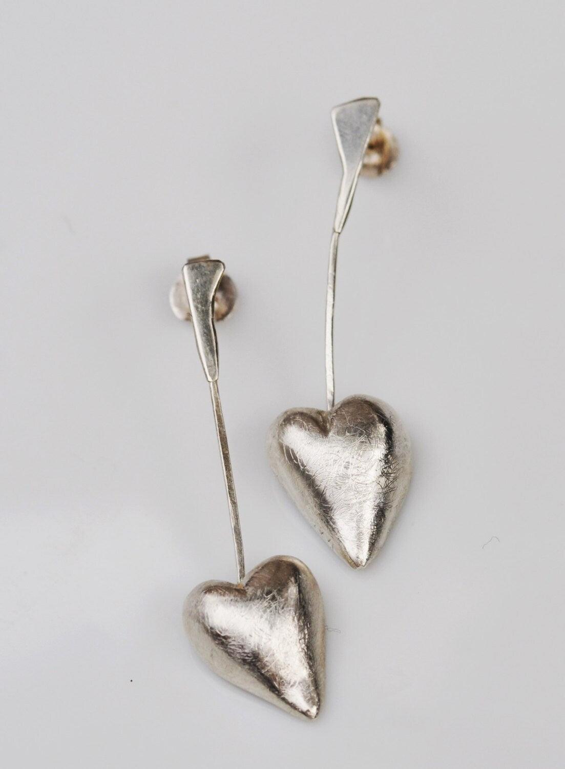 a pair of heart shaped earrings on a white background