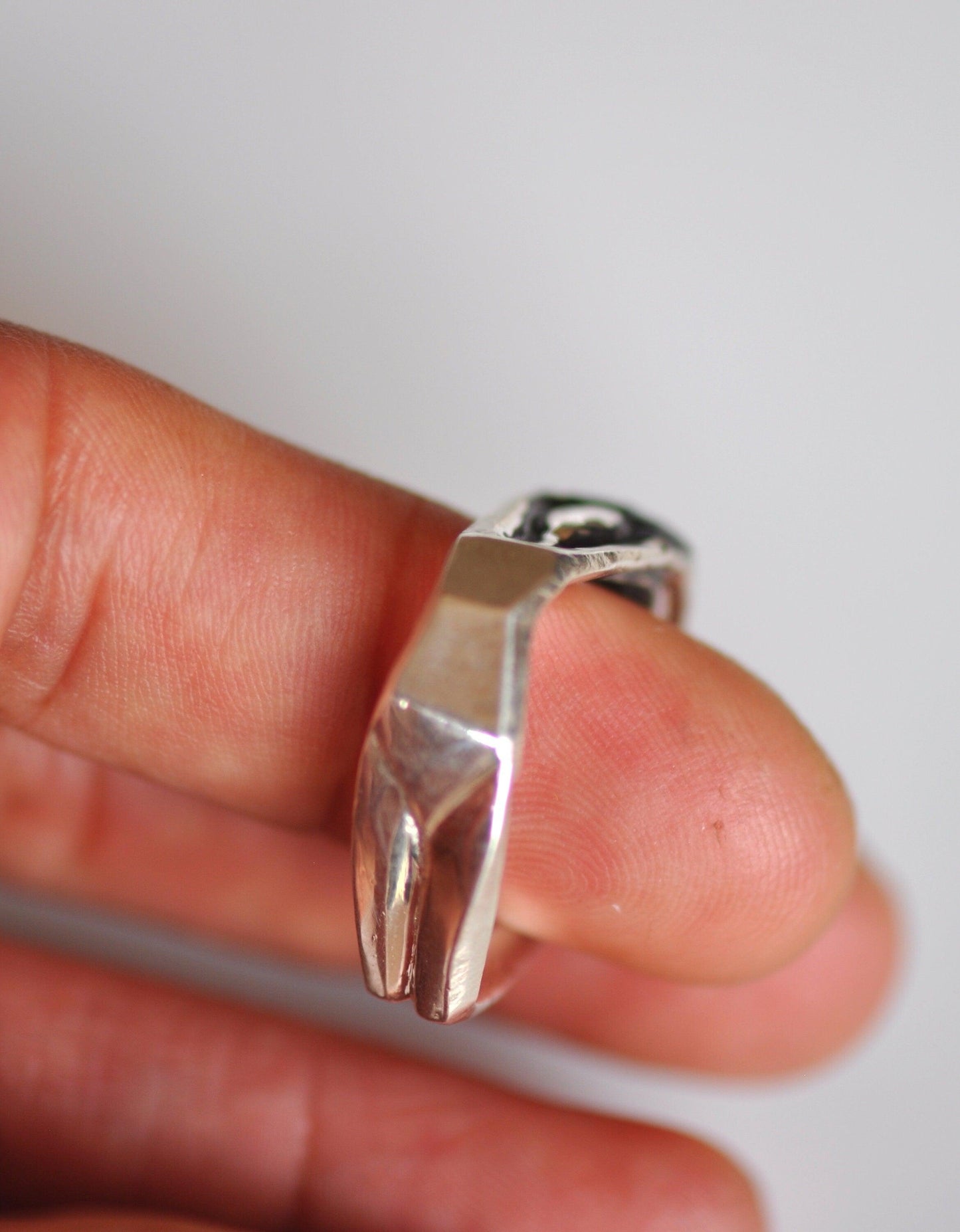 a person holding a silver ring in their hand