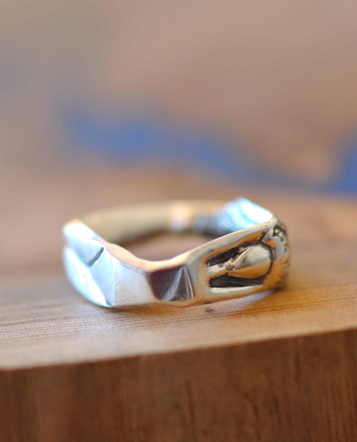 a silver ring sitting on top of a wooden table