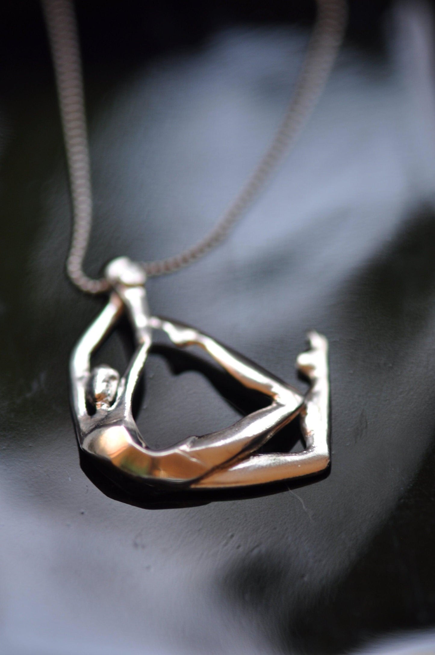 a silver necklace with a figure on it