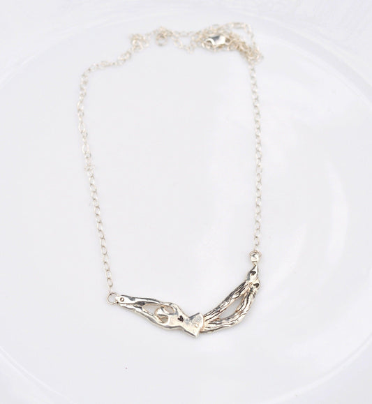 a white plate with a silver necklace on it