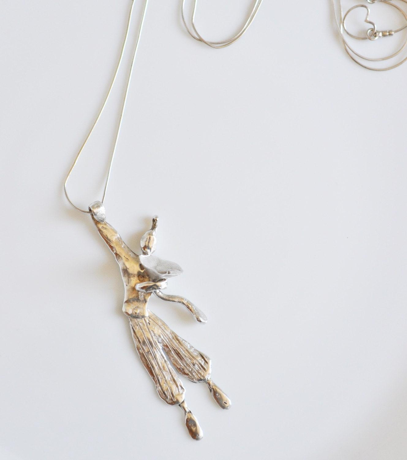 a necklace with a bird hanging from it's side