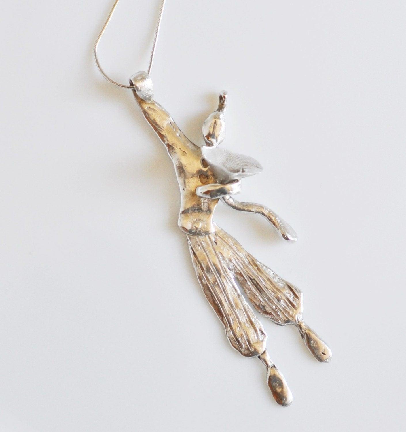 a silver pendant with a bird on it