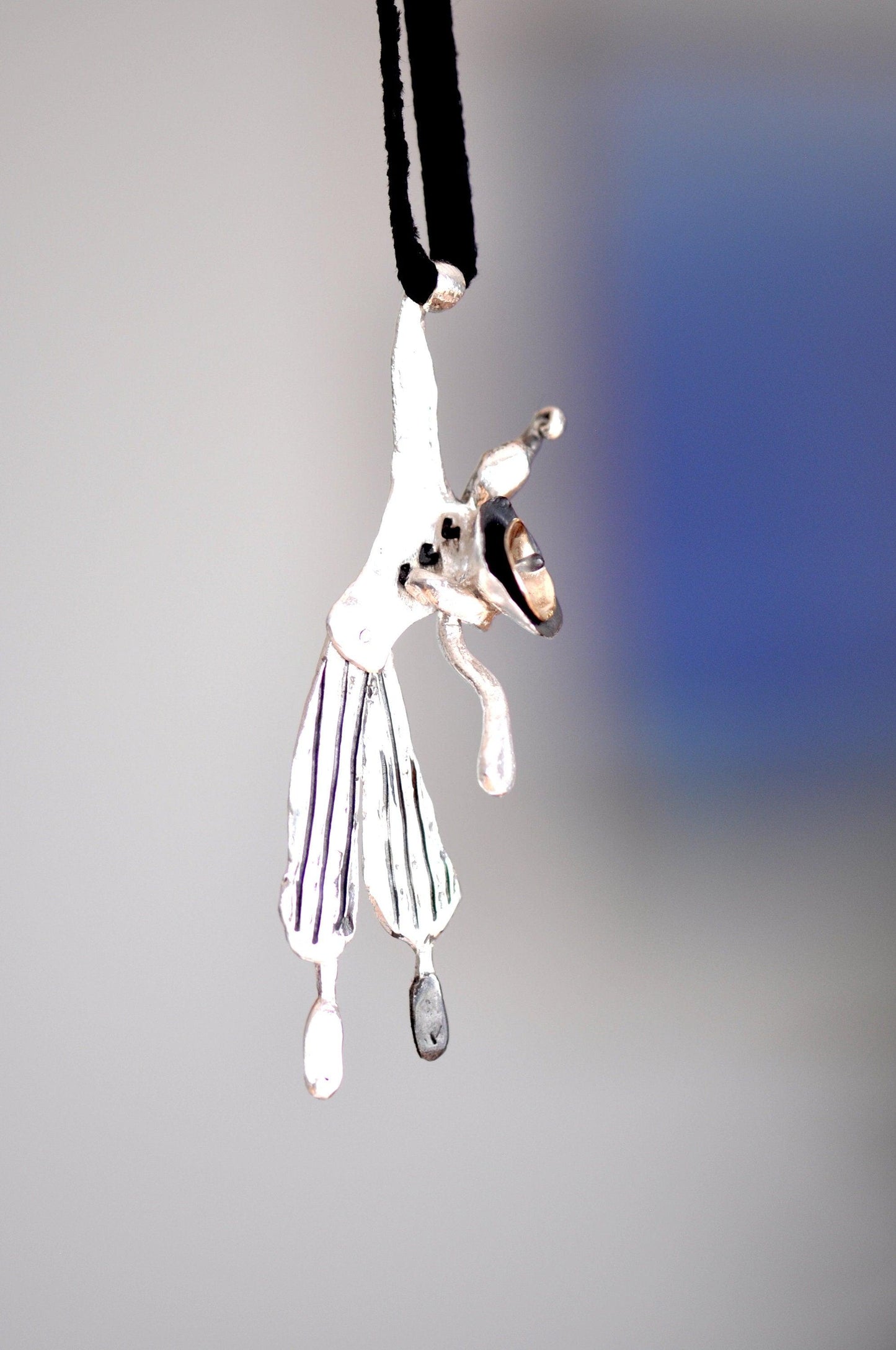 a white and black dog hanging from a black cord