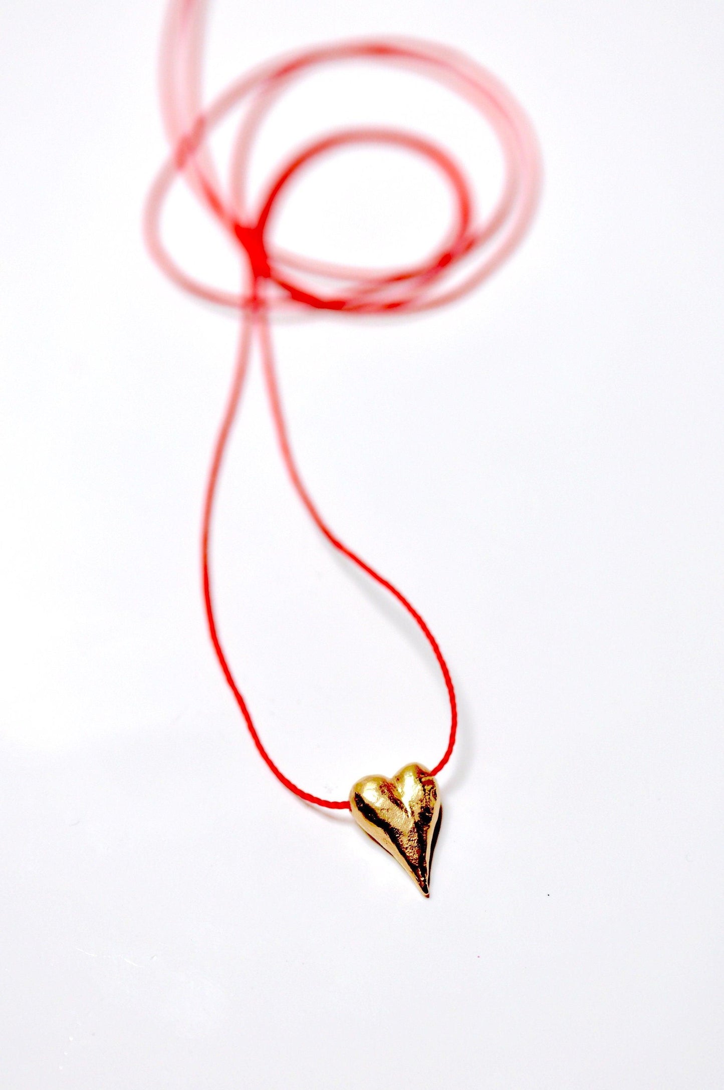 a red string with a gold heart on it