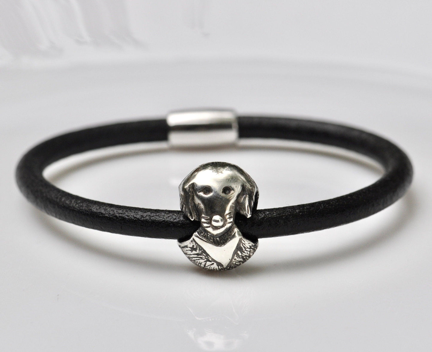 a black leather bracelet with a silver dog head