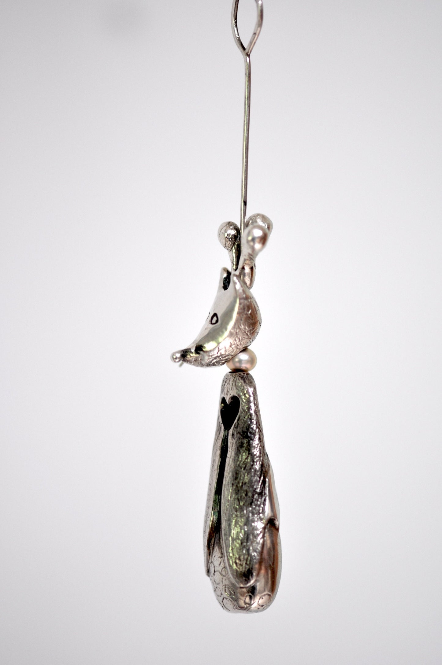 a glass ornament hanging from a metal hook