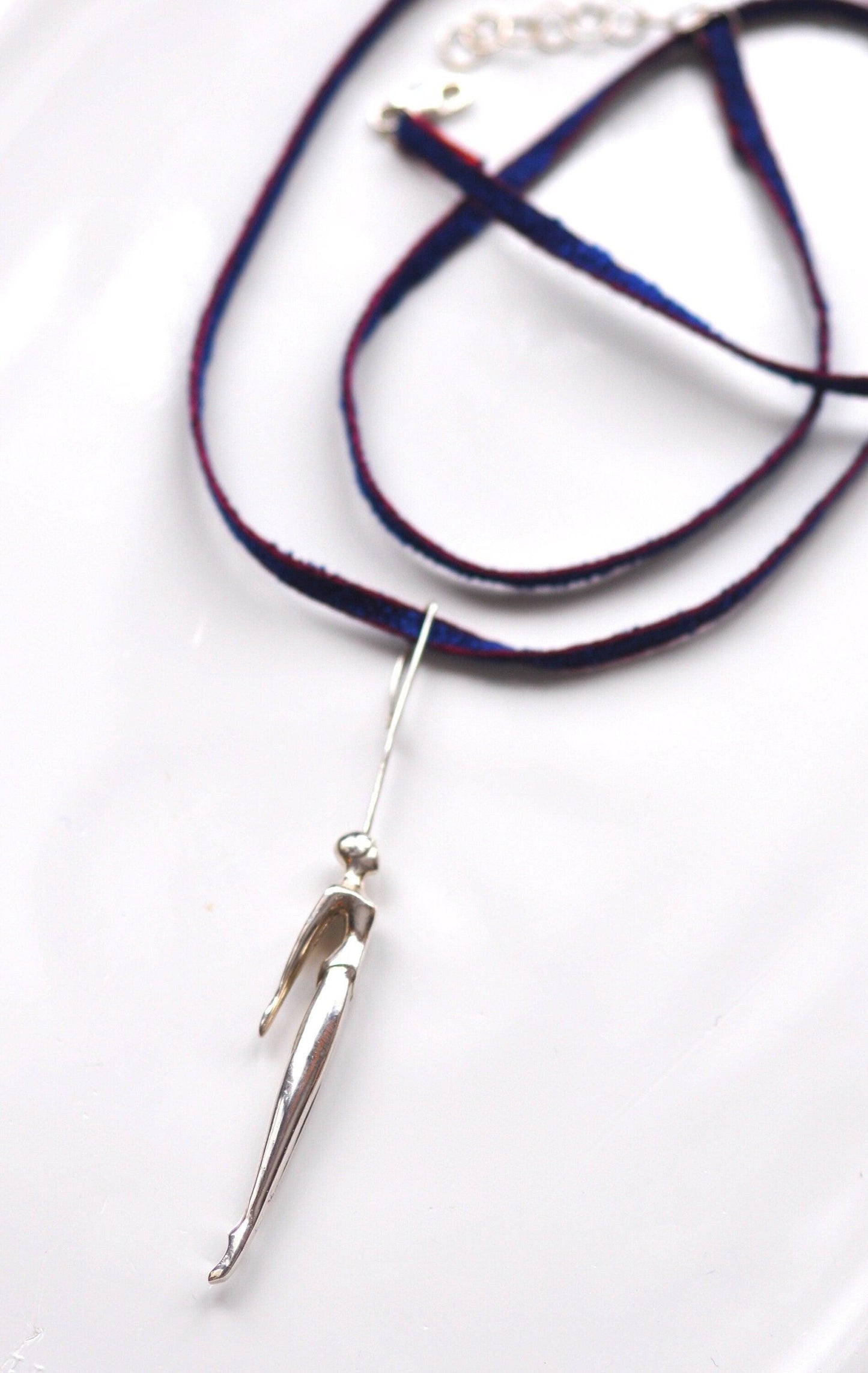 a white plate with a blue cord and a metal hook