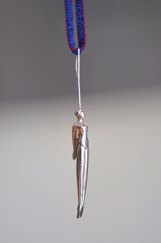 a silver bird hanging from a blue string