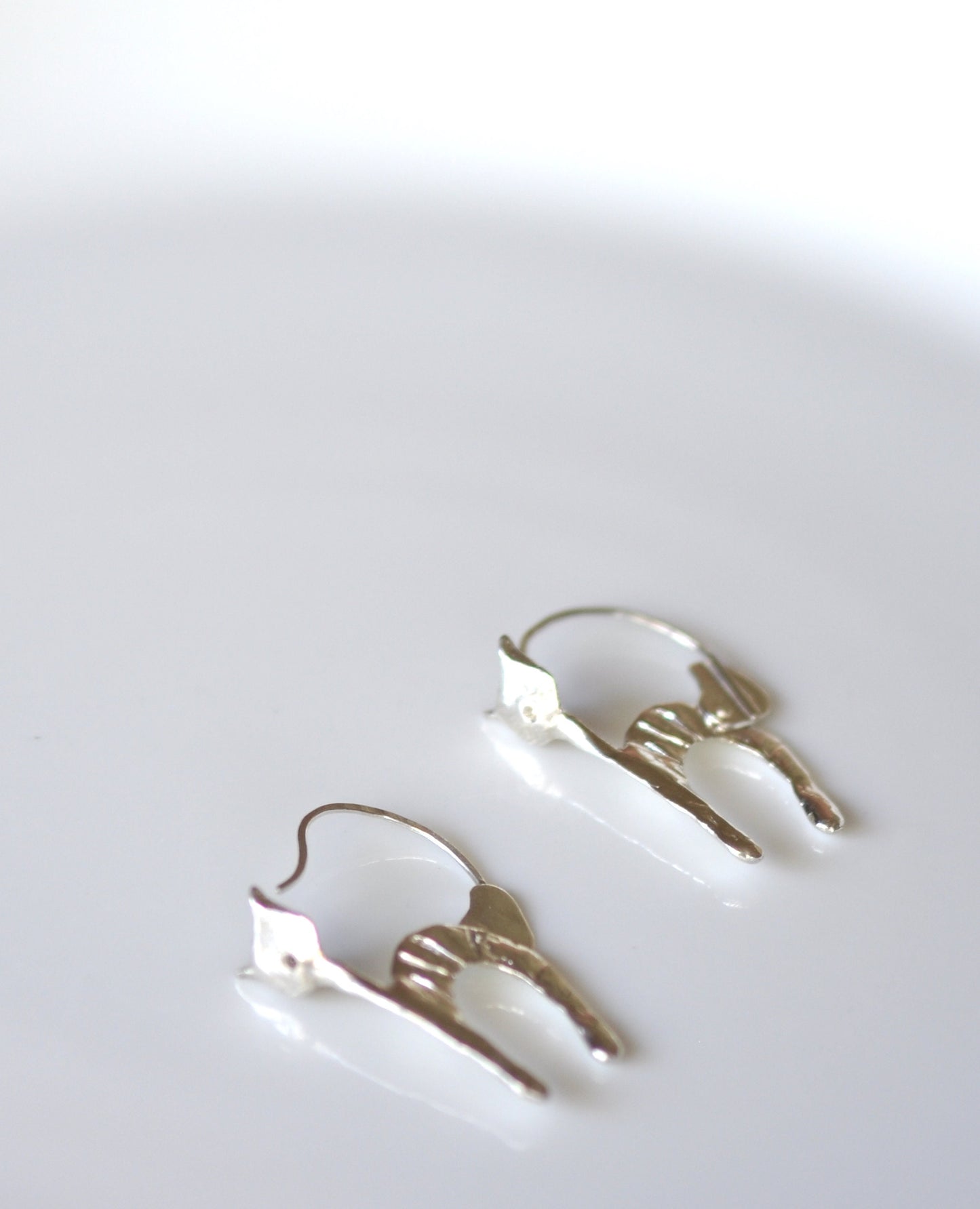 a pair of earrings sitting on top of a white table