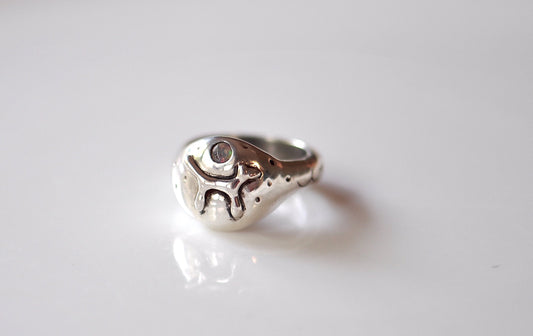 a close up of a silver ring on a white surface