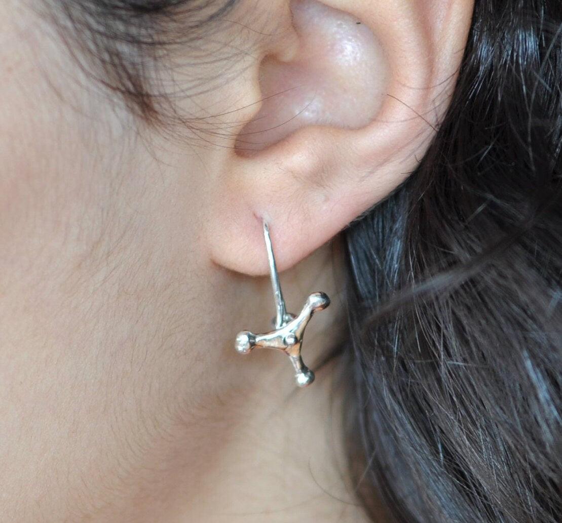 a close up of a person wearing a pair of earrings