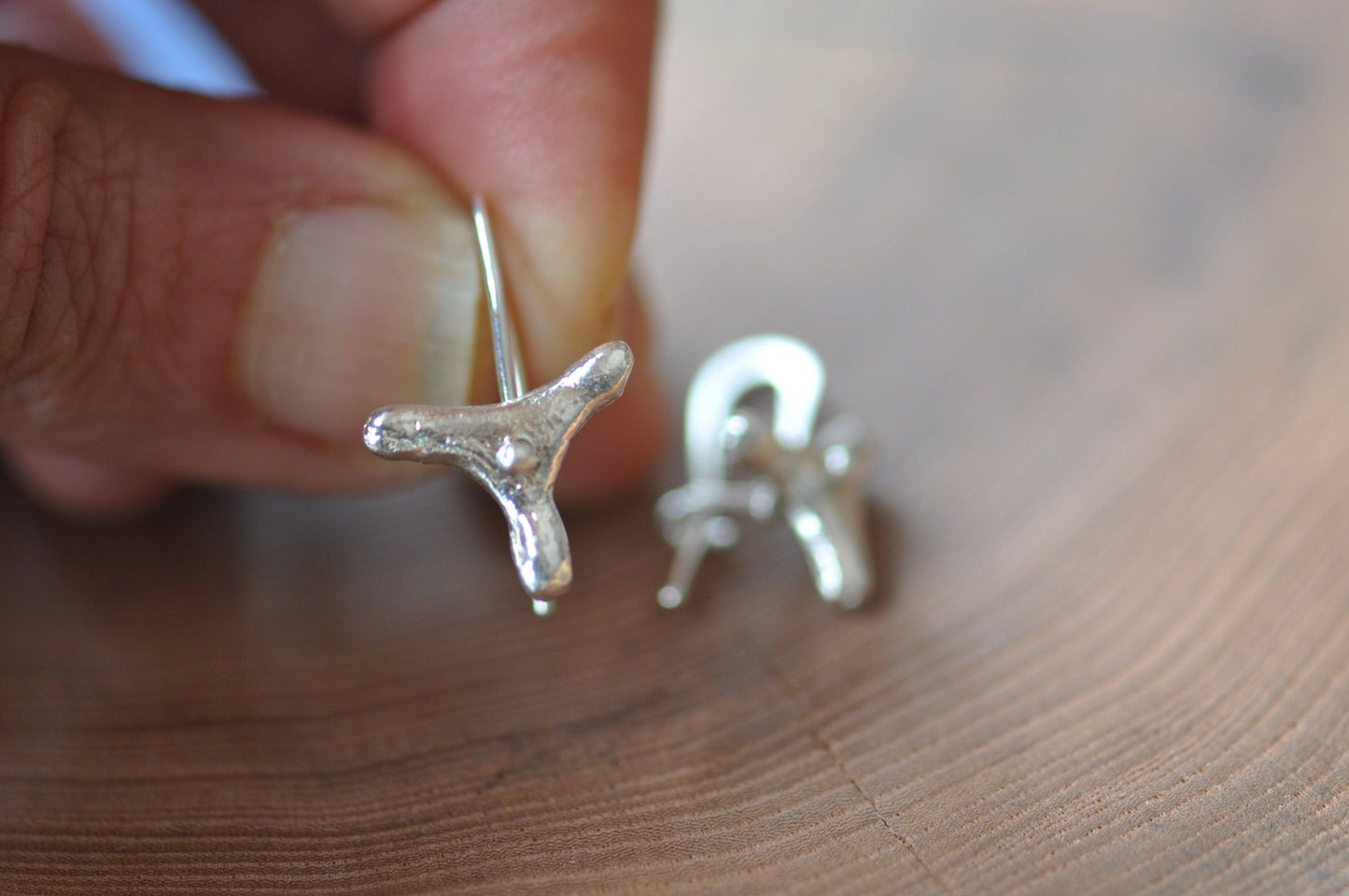 a close up of a person holding a pair of earrings