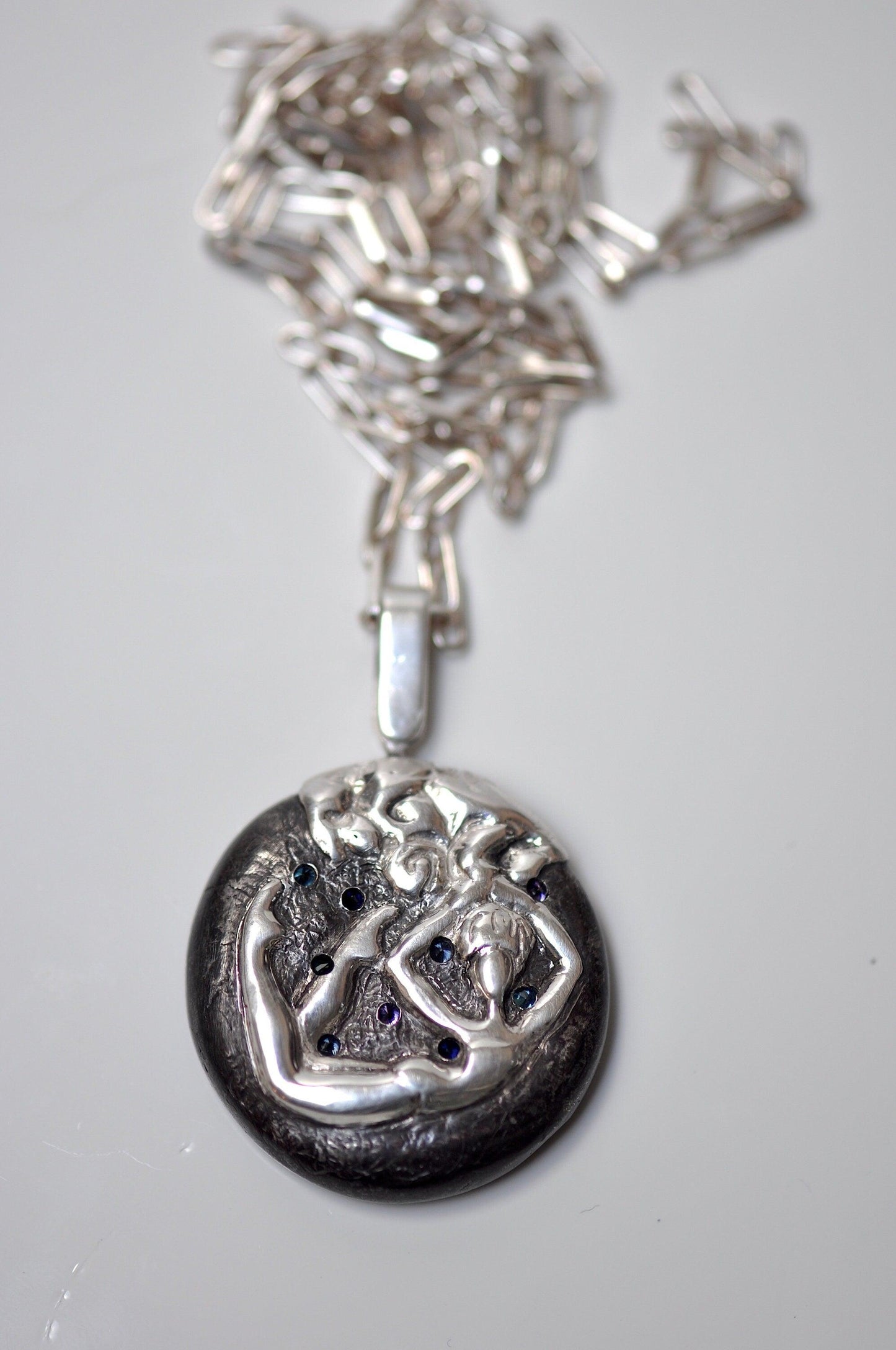 a silver necklace with a picture of a woman on it