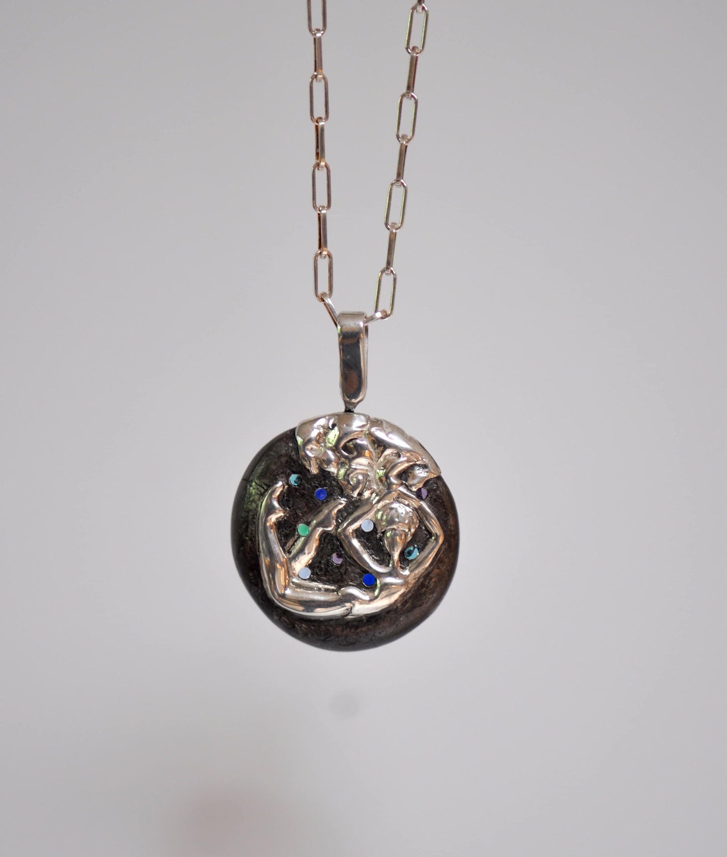 a silver necklace with a picture of a woman on it