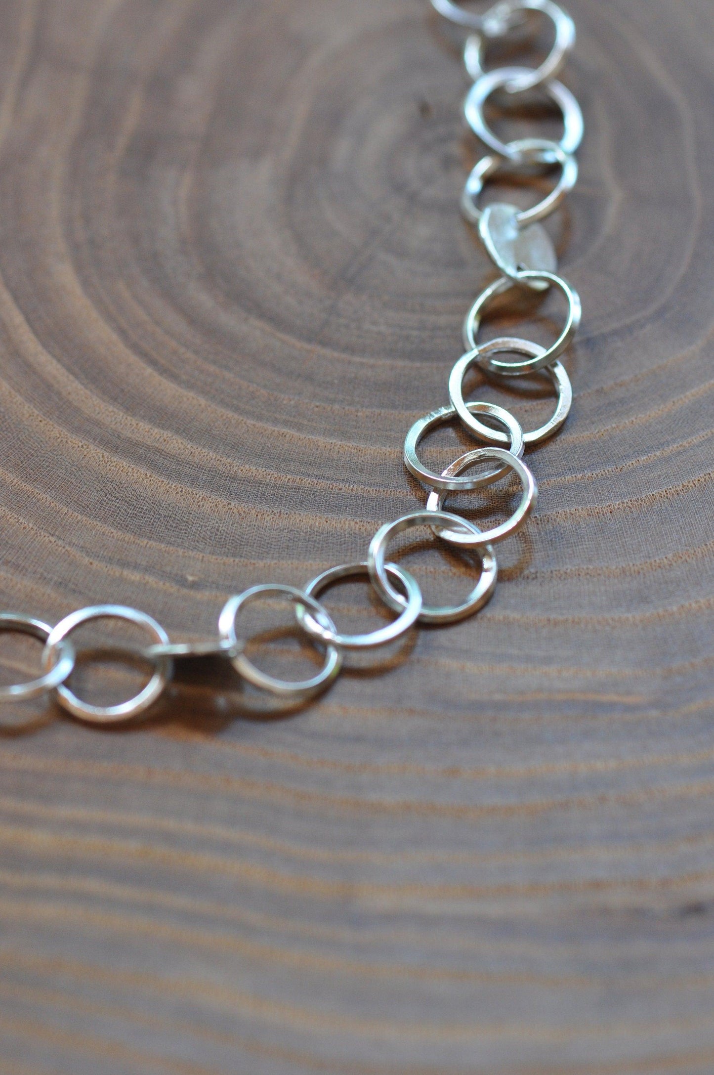 a close up of a chain on a wooden surface