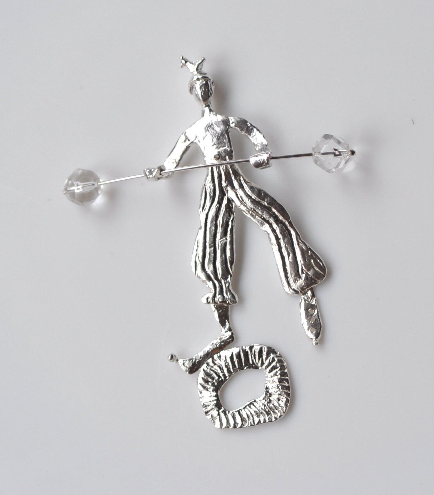 a silver figurine of a man holding a stick