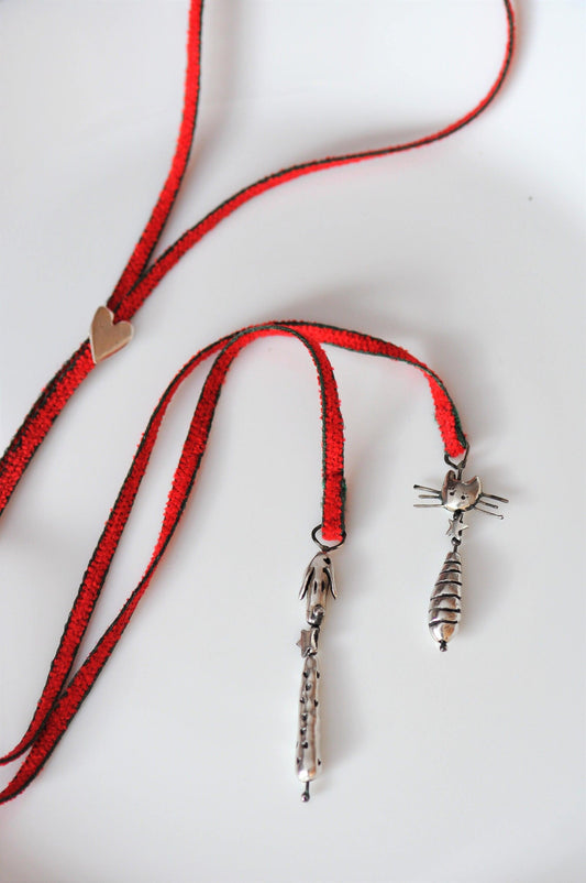 a red cord with a silver cat on it