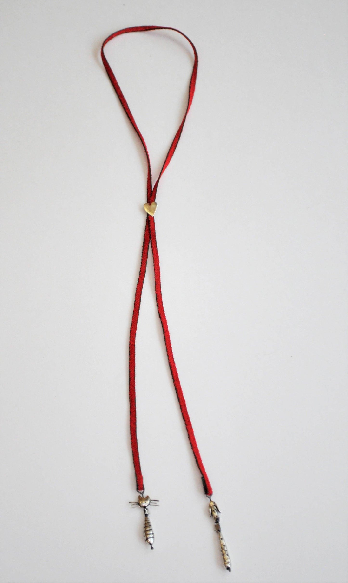 a red lanyard with a silver cross on it