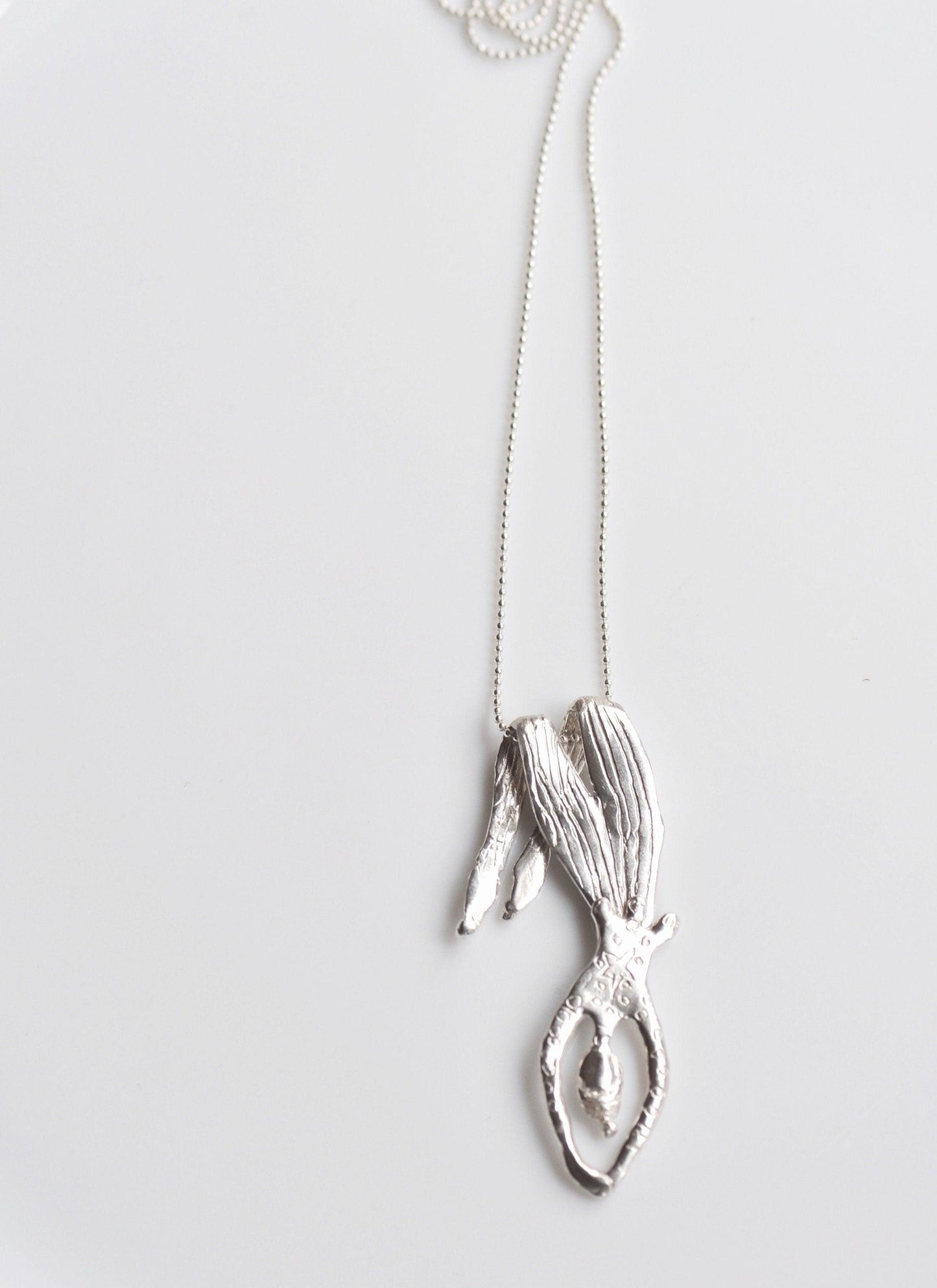 a silver necklace with a sea horse on it