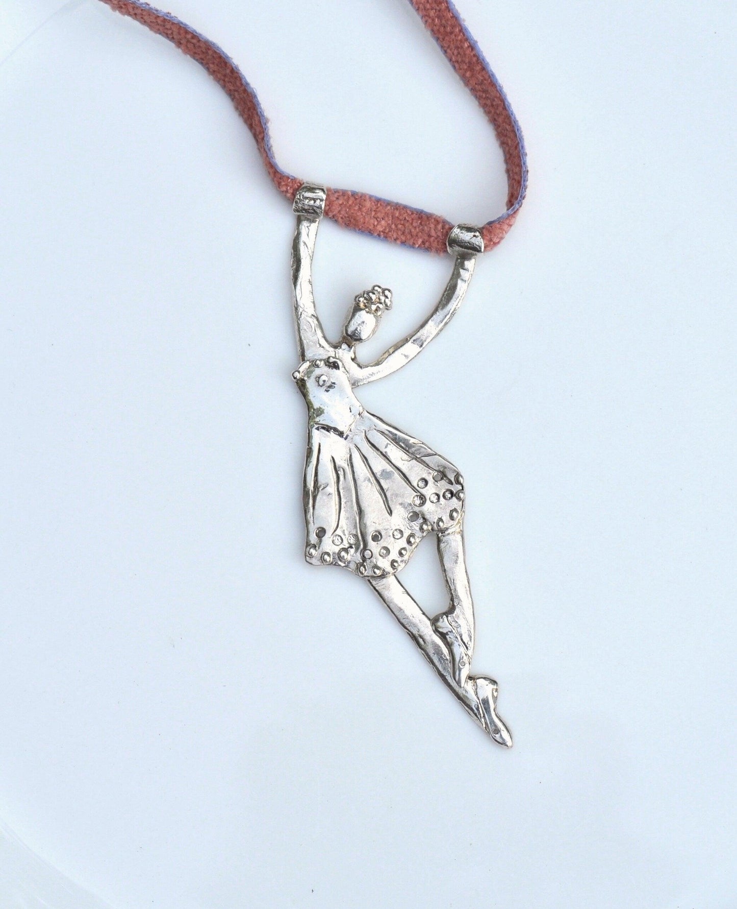 a silver necklace with a ballerina on it