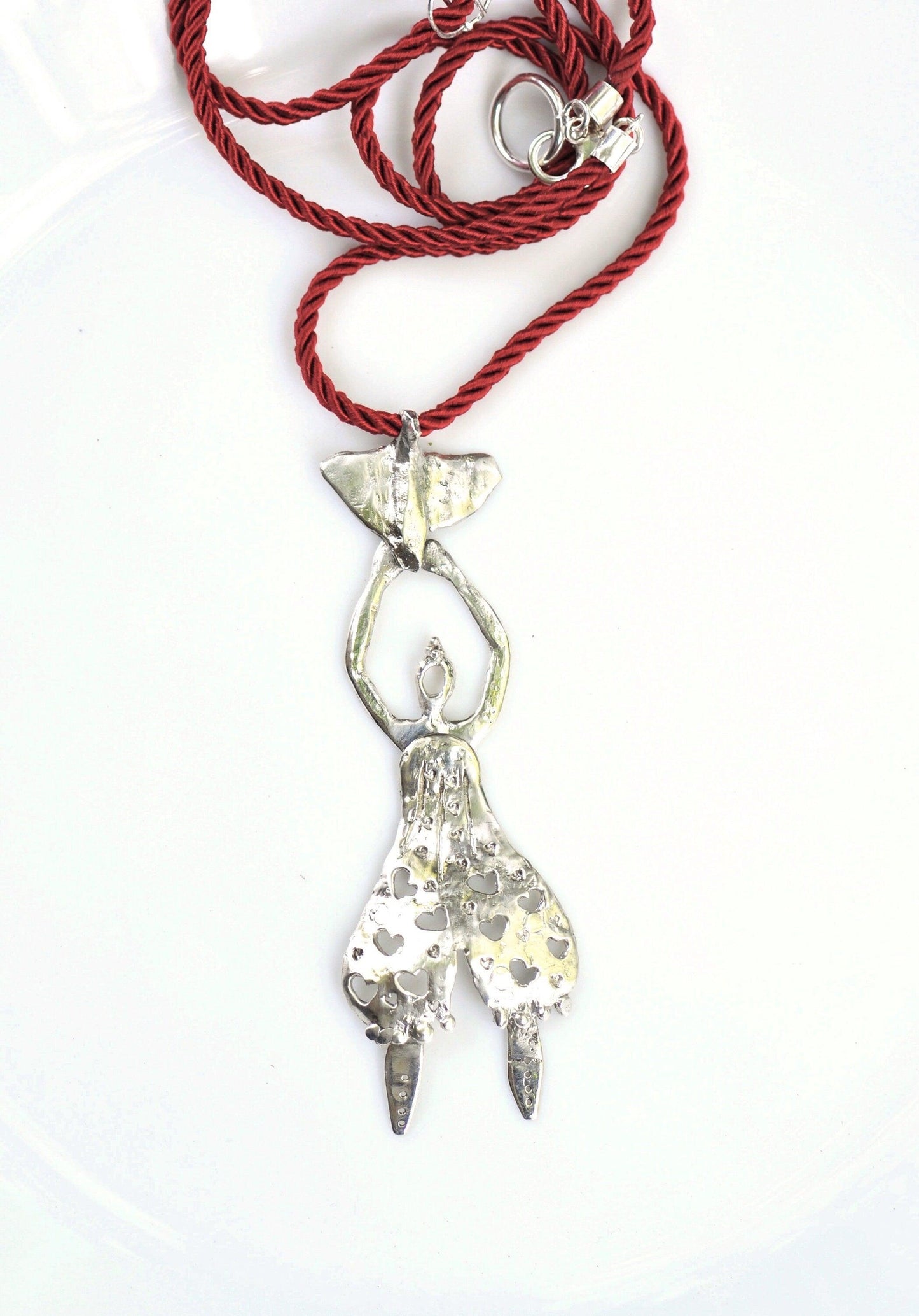 a red rope with a silver pendant on it