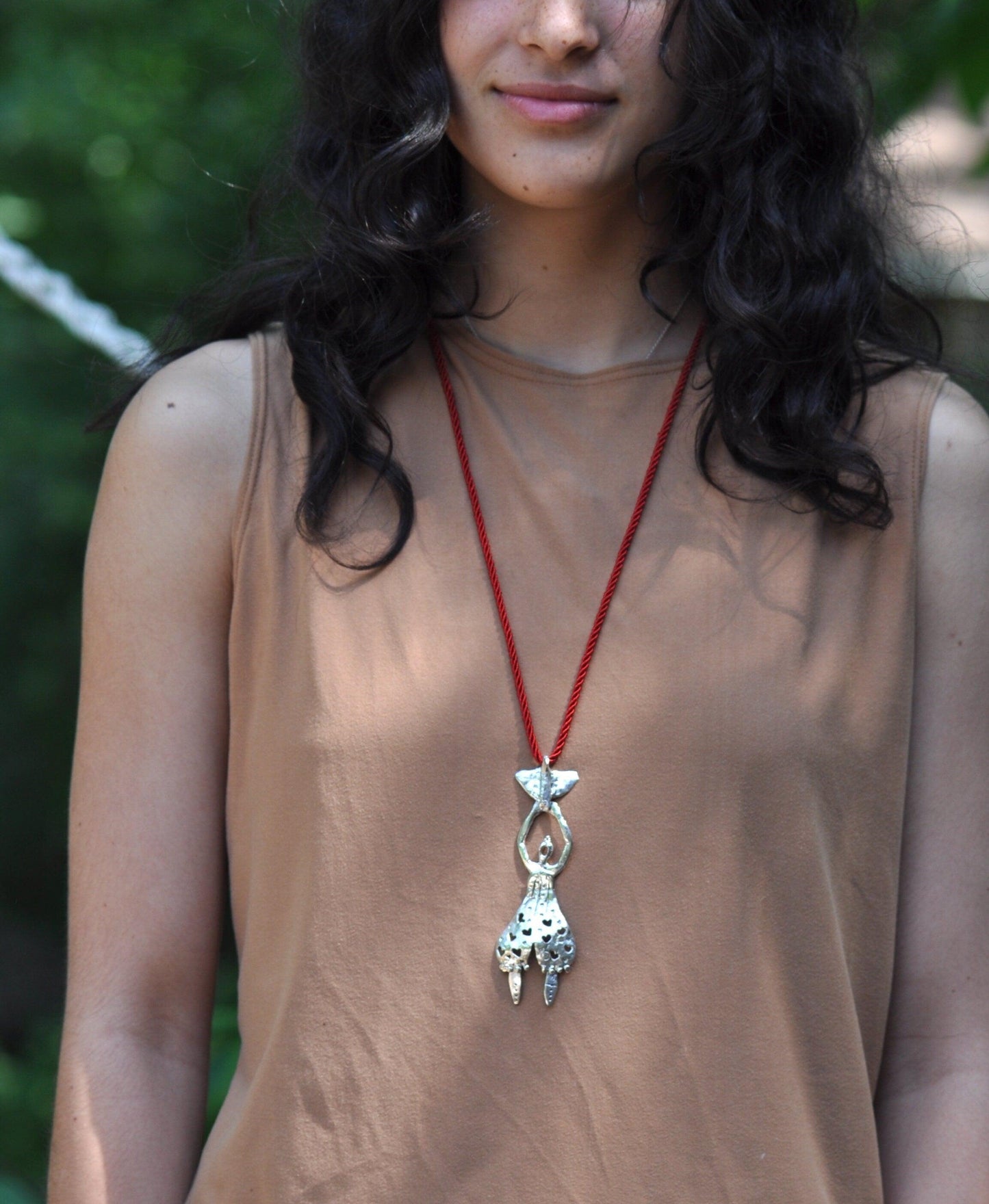 a woman with long black hair wearing a necklace