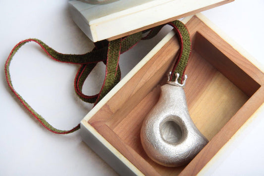 a silver vase sitting inside of a wooden box